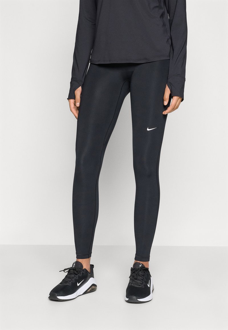 Black athletic leggings with a smooth texture and a fitted design, featuring a small white Nike logo on the upper leg. Paired with black sneakers.