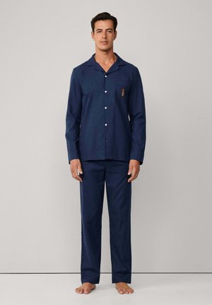 Ensemble de pyjama en coton bleu marine comprenant une chemise à boutons avec une poche et des détails brodés, assortie à un pantalon, sans motifs, coupe décontractée.