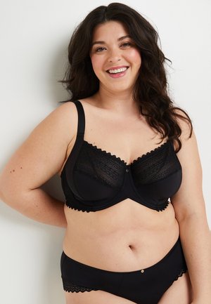 Ensemble de lingerie noire comprenant un soutien-gorge avec des accents en dentelle, des bordures festonnées et une bande sous poitrine lisse, associé à un slip assorti.