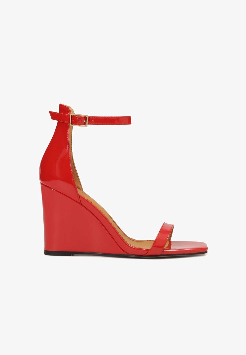 Sandales compensées en cuir verni rouge avec bride à la cheville, bout ouvert et design élégant ; elles présentent une finition lisse et brillante ainsi qu'un talon compensé épais.