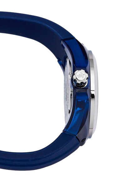 Reloj con correa de silicona azul, caja plateada, esfera redonda y corona lateral. Presenta una textura suave y un diseño minimalista.
