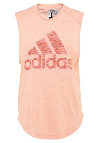 Débardeur de sport sans manches rose clair avec un grand logo rouge Adidas sur le devant, fabriqué dans un tissu doux et texturé.
