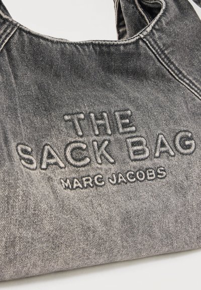 Γκρι τσάντα από τζιν ύφασμα με κεντημένα τα λόγια «THE SACK BAG» και «MARC JACOBS» στο μπροστινό μέρος με κλωστή που ταιριάζει στο χρώμα.