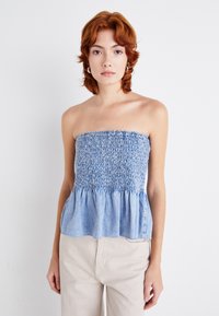Kjole uten stropper i blå denim med samlet midje og utvidet kant. Stoffet har en myk tekstur og en subtil tie-dye-effekt.