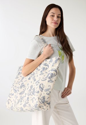 Borsa a tracolla in cotone con sfondo crema e motivo paisley blu intricati. Presenta spallacci larghi e un design spazioso.