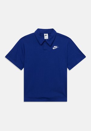 Μπλε μπλουζάκι πόλο Nike με κοντά μανίκια, γιακά και λευκό λογότυπο Nike στο αριστερό στήθος, τοποθετημένο επίπεδα σε φωτεινή επιφάνεια.