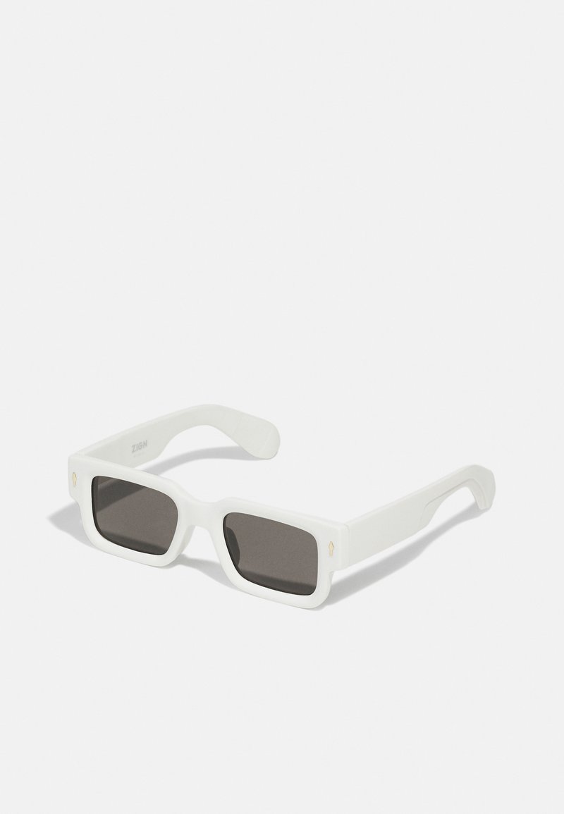 Gafas de sol rectangulares blancas con lentes oscuros. Presentan un acabado mate, patillas planas y sutiles acentos dorados en los lados frontales.