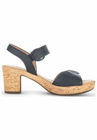 Sandale noire à bout ouvert avec talon bloc en liège et bride de cheville avec fermeture Velcro, vue de côté sur fond blanc.