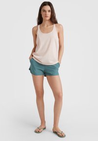 Ljust rosa linne, teal shorts och gröna flip-flops. Linnet har en rundad halsringning, och shortsen är lätta med fickor.