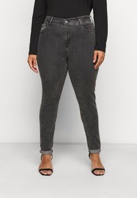 Mörkgrå högmidjade jeans med slim fit, som har fem fickor, knappstängning framtill och uppvikta muddar, tillverkade av denimtyg.