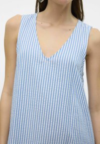 Plava i bijela prugasta majica bez rukava s dubokim V-izrezom, izrađena od lagane tkanine; ima opušteni kroj i suptilnu teksturu.
