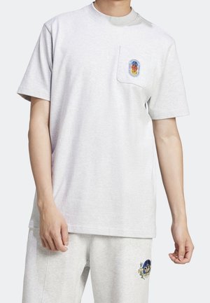 Lysegrå bomulds-t-shirt med rund halsudskæring, korte ærmer og en brystlomme med et farverigt grafisk emblem.
