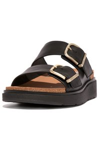 Zwarte leren slip-on sandaal met twee verstelbare gouden gespen, een kurken voetbed en een gestructureerde zwarte rubberen loopzool.