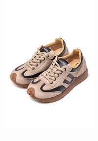 Sneakers beige in camoscio con accenti neri, punta tonda e suola in gomma testurizzata. Lacci con collare imbottito e logo sulla linguetta.