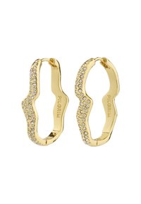 Orecchini a cerchio d'oro con un design ondulato, adornati con strass trasparenti su un lato. Presentano metallo lucidato e una texture liscia.