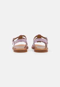 Lilla strappy sandaler med brun såle, med justerbar spenne og åpen design. Glatt tekstur med flat hel.