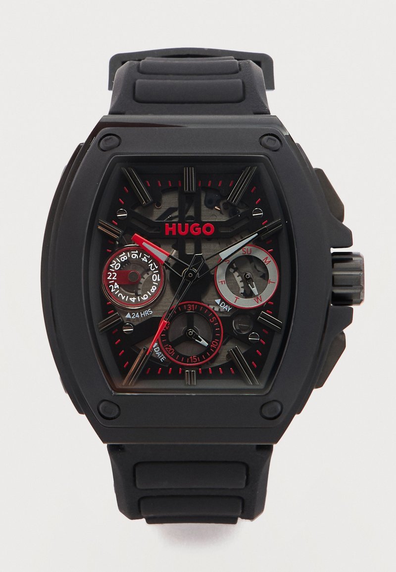 Μαύρο ρολόι χειρός Hugo με ορθογώνιο καντράν, κόκκινες λεπτομέρειες, τρεις υποδιακόπτες που δείχνουν 24ωρο, ημέρα και ημερομηνία, και μαύρο λουράκι από σιλικόνη.