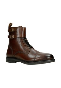 Stivaletto alla caviglia in pelle marrone con chiusura con lacci, due fibbie decorative nella parte superiore, punta arrotondata e suola piatta nera. Finitura texturizzata.