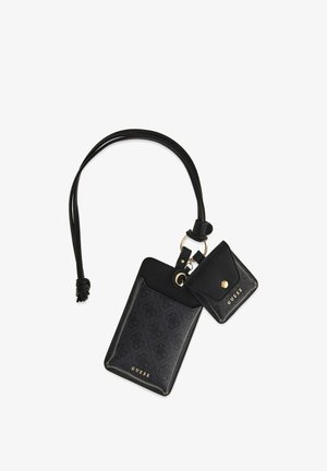 Zwarte Guess polszak met monogrampatroon, bevestigd met een klein muntenportemonneetje met drukknoopsluiting, beide verbonden door een leren lus en gouden ring.