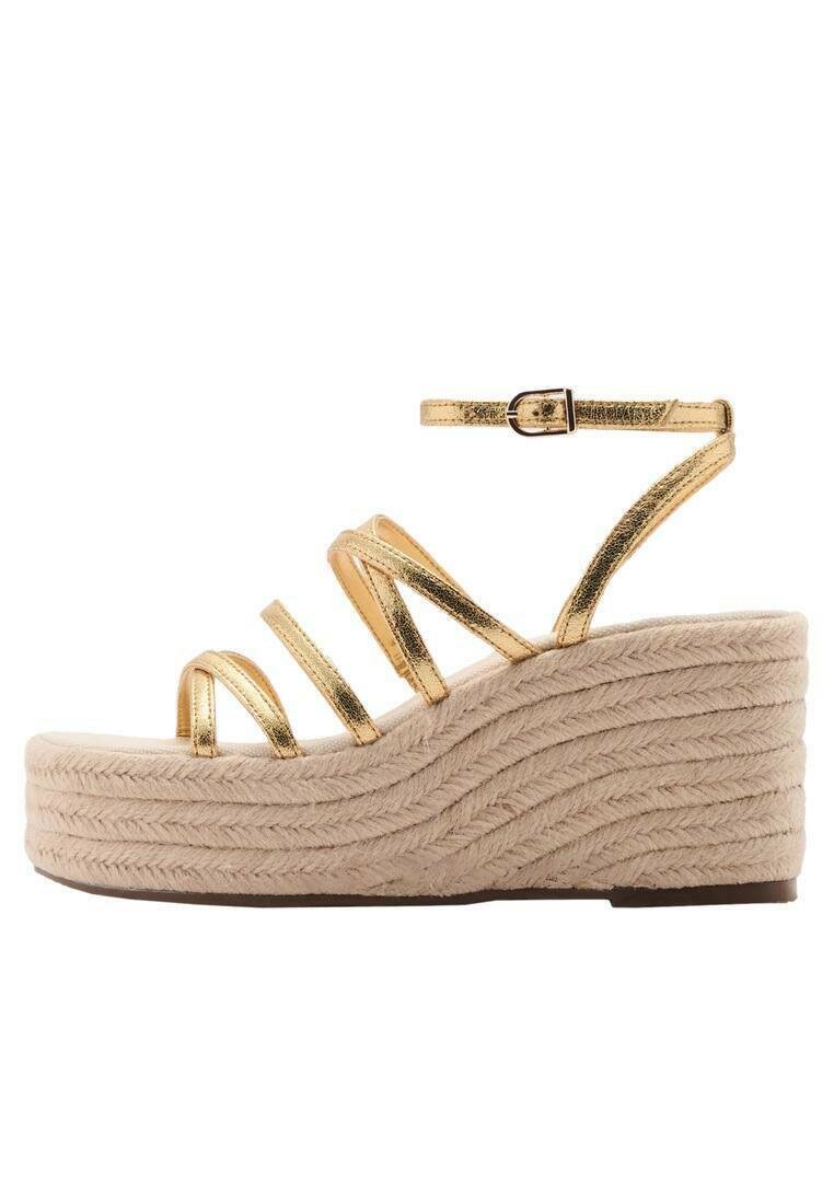 Guldmetalliska remsandaler med kilklack och en tjock vävd beige plattformshæl, med en spännesträng och texturerad yta.