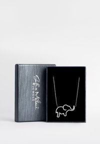 Collana con pendente a forma di elefante argento su una delicata catena, esposta all'interno di una scatola foderata in velluto nero con un coperchio accentato in argento.