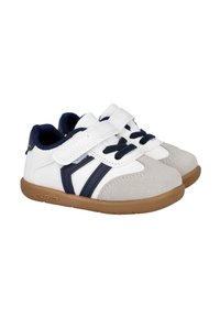 Zapatillas infantiles en blanco y marino con punta de ante gris, correas de velcro y suelas de goma. Presentan rayas diagonales en color marino en los costados.