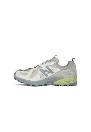 Zapatillas de running ligeras en blanco y gris con parte superior de malla, puntera reforzada y una suela texturizada en verde y gris para mayor tracción.