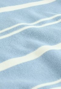 Tessuto azzurro chiaro con strisce orizzontali bianche, caratterizzato da un motivo a maglia testurizzato. Il materiale sembra morbido e leggermente elastico.