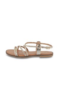 Metallieke gouden sandaal met gevlochten banden, platte ontwerp, open teen en enkelgesp. Heeft een gladde bruine binnenzool en een minimalistische hak.