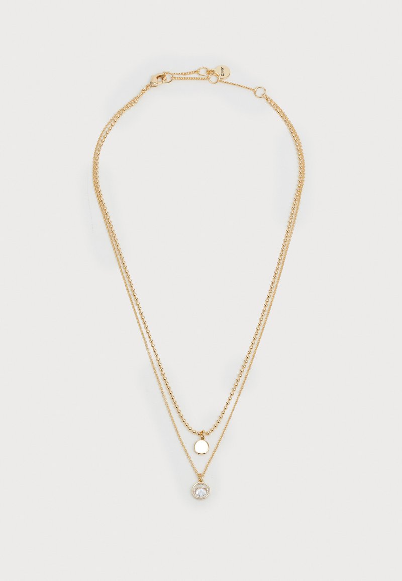 Collana a strati color oro con due catene: una presenta un design a perline e l'altra ha un pendente circolare con una goccia di pietra preziosa trasparente.