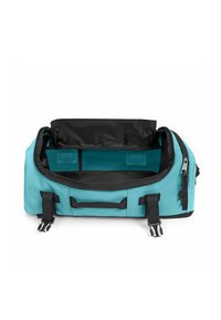 Sac polochon bleu sarcelle avec intérieur noir, équipé de deux poignées, de bretelles réglables et d'une fermeture à glissière. Compartiments intérieurs pour l'organisation.