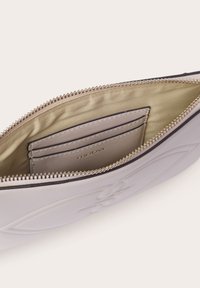 Borsa grigia chiara con zip realizzata in materiale sintetico liscio, dotata di una fodera interna dorata, slot per carte e design floreale impresso.