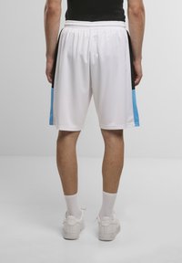 Shorts atletici bianchi con pannello laterale nero e accenti blu, realizzati in tessuto leggero, con vita elasticizzata e vestibilità rilassata.