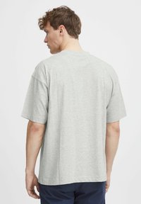 Lys grå kortærmet T-shirt med afslappet pasform, rund halsudskæring og glat tekstur. Enkel design uden mønstre eller grafik.