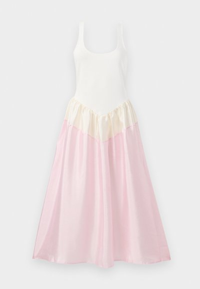 Maxi sukienka z dopasowaną białą górą i zwiewnym dołem. Dół sukienki jest wykonany z warstwowych tkanin w kolorze kremowym i jasnoróżowym, z błyszczącą teksturą.