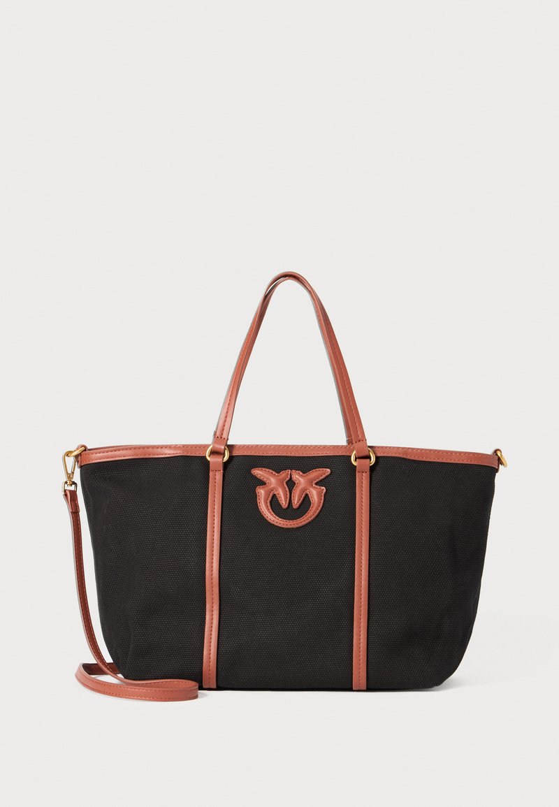 Črna platnena torba s svetlobrnimi usnjenimi dodatki in ročaji, z logotipom spredaj, pravokotne oblike in nastavljivim pasom.