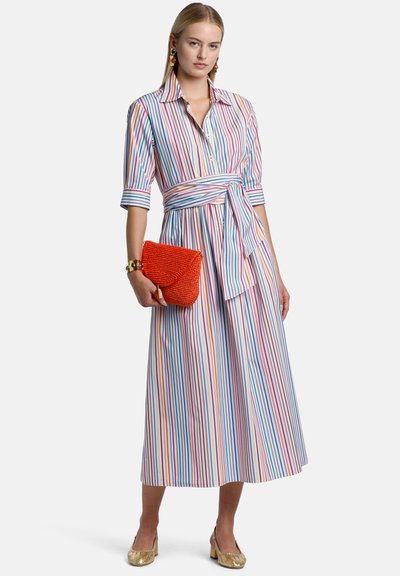Striped dress with button front, waist tie, short sleeves, and a flowing skirt. Accessories include a small orange bag and gold shoes.