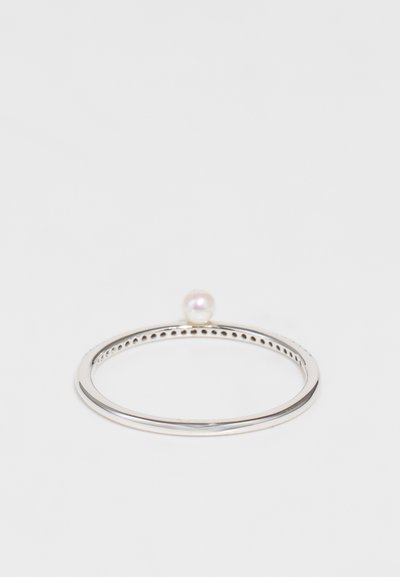 Ezüst gyűrű sima, vékony szalaggal, amelyen egyetlen gömb alakú gyöngy dísz található a tetején. A design minimalista, fényes felületű.