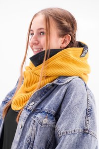 Knitted yellow scarf with a textured design, wrapped snugly around the neck, paired with a black collar jacket.