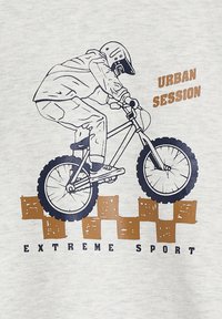 Grauer Sweatshirt mit einem Grafikmotiv eines Radfahrers auf einem Fahrrad, umrandet in Blau und mit braunem Text "URBAN SESSION" und "EXTREME SPORT."