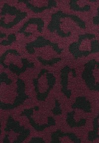 Tissu tricoté rouge foncé avec un motif léopard noir irrégulier réparti uniformément sur toute la surface.