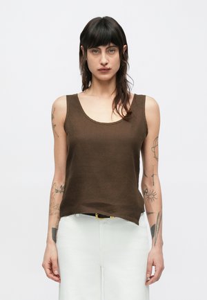 Barna len anyagú ujjatlan top mély kivágással, laza fazonban, világos színű nadrággal párosítva. Texturált szövet finom fénylő hatással.