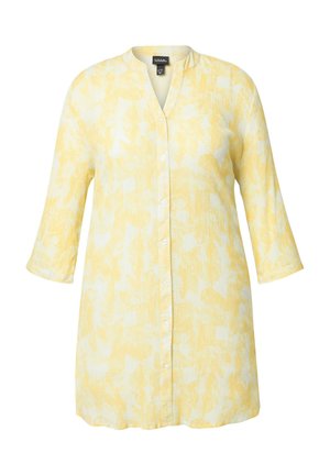 Gul skjorte med knapper i let, tekstureret stof. Har en v-halsudskæring og trekvartærmer, prydet med et diskret bladmønster.