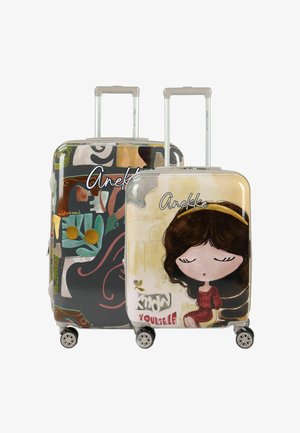 Due valigie rigide colorate con manici e ruote in stile gattino; la valigia anteriore presenta una ragazza dei cartoni animati e il testo "Conosci te stesso."