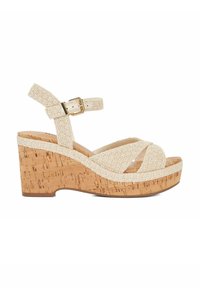 Beige woven wedge sandals with an ankle strap, cork platform, and textured detailing. Features crisscross straps and a light, natural aesthetic.