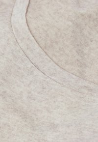 Hellgrauer Stoff mit weicher Textur und leicht meliertem Muster. Verfügt über einen glatten, runden Ausschnitt und einen entspannten Fall.