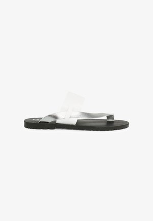 Silver flip-flop sandal with a flat black sole, featuring metallic straps and a transparent accent. Minimalist design and lightweight construction.
