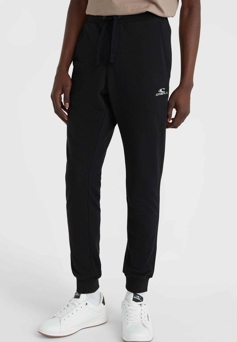 Schwarze Jogginghosen mit einem Kordelzugbund, schmalen Bündchen und einem kleinen weißen Logo. Hergestellt aus weichem Stoff, mit einer glatten Textur und geraden Beinen.