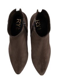 Un paio di stivali alla caviglia in suede marrone scuro con cerniere laterali e punte appuntite, visti dall'alto su uno sfondo bianco.