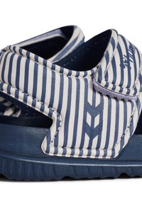 Niebiesko-białe sandały w paski wykonane z materiału syntetycznego, z elastyczną podeszwą, regulowanym paskiem i teksturowanymi akcentami.